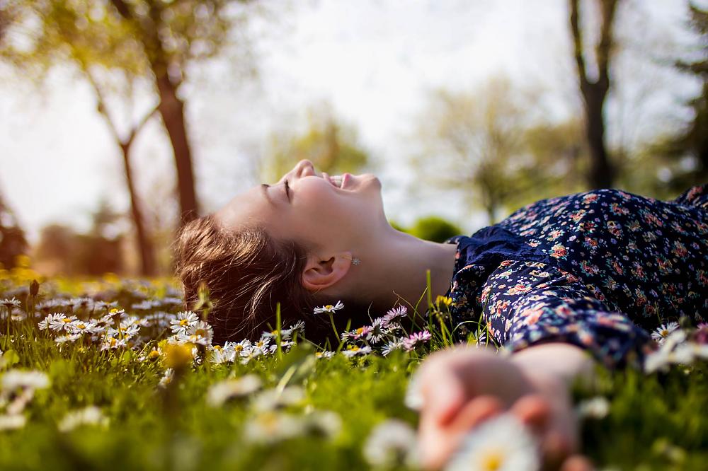 Young adult laying on a bed of wildflowers